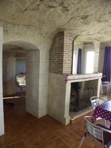 Zimmer mit Kamin, Tisch und Stühlen in der Unterkunft Les Hauts de Nazelles in Nazelles