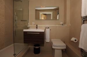 y baño con lavabo, aseo y espejo. en Tower Apartments, en Southend-on-Sea