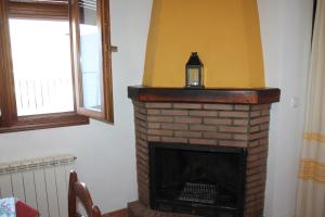 a brick fireplace with a lantern on top of it at Apartamentos Rurales Rosendo: La Canela in Capileira