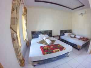 een kamer met 2 bedden in een kamer bij Jelajah Batukaras in Batukaras
