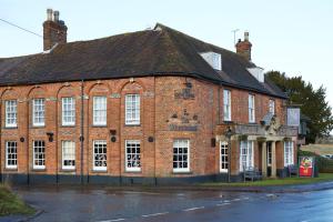 an old red brick building on the side of a street at Wheatsheaf by Chef & Brewer Collection in North Waltham