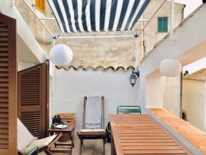 un patio esterno con tavoli e sedie in legno di Holidaycasa Mirella - Nel cuore del centro storico a Sperlonga