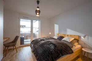 a bedroom with a large bed and a balcony at Goasblick - by NV Appartements in Kirchberg in Tirol
