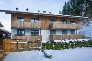 a house with a fence in the snow at Goasblick - by NV Appartements in Kirchberg in Tirol