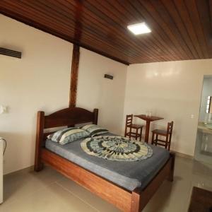 1 dormitorio con 1 cama con mesa y sillas en Toca do Capitao, en Boicucanga