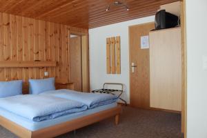 ein Schlafzimmer mit einem Bett mit einer Holzwand in der Unterkunft Hotel Alpha in Grächen