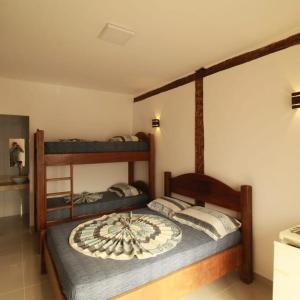 a bedroom with two bunk beds in a room at Toca do Capitao in Boicucanga