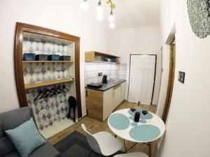 um pequeno quarto com uma mesa e uma cozinha em IL-LAK Apartment em Pannonhalma