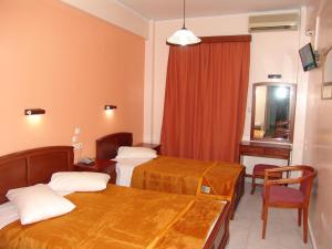 a hotel room with three beds and a mirror at Hotel Cosmos in Athens