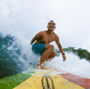 a man riding a wave on a surfboard at Jelajah Batukaras in Batukaras