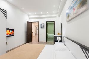 Cette chambre est dotée de murs blancs et d'un couloir avec un canapé. dans l'établissement The Grand Apartment l, à Tbilissi