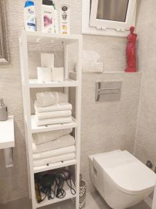 ein Badezimmer mit einem weißen Regal mit Handtüchern und einem WC in der Unterkunft Family Deluxe Apartment Beach in Castelldefels + 32 Fotos