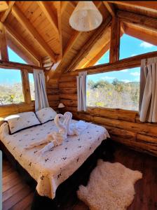 1 dormitorio con 1 cama en una cabaña de madera en costa bonita el bosque en Villa Pehuenia