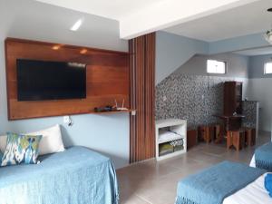 a hotel room with two beds and a flat screen tv at DaMa 1 in Tiradentes