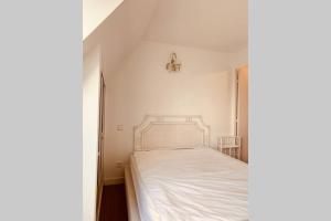 une chambre avec un lit blanc dans une pièce dans l'établissement Triangle d'or, à Le Touquet-Paris-Plage