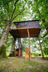 a tree house in a park with a fire hydrant at La ferme de Piardiere in Plessé