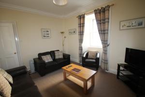 a living room with a couch and a coffee table at Covesea Lighthouse Cottages in Lossiemouth