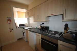 a kitchen with a sink and a stove top oven at Covesea Lighthouse Cottages in Lossiemouth