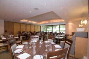 uma sala de jantar com mesas e cadeiras de madeira em Regency Park Hotel, Health Club & Spa em Newbury