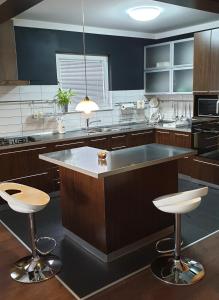 a kitchen with a large island with stools in it at Apartmani Sanja in Krapinske Toplice