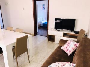 a living room with a couch and a table with a television at Point Elyseum Apartament in St Julian's