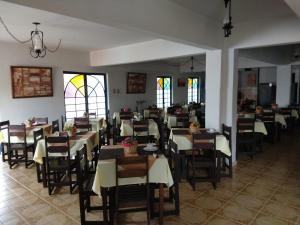 a dining room with tables and chairs and stained glass windows at Hotel Pousada São Miguel in Baependi