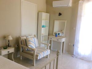 a room with a chair and a table and a mirror at Kefalonia apartments: cute studios in orchard, Spartia in Spartia