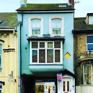 a blue building with white windows on a street at The Gatehouse in Folkestone