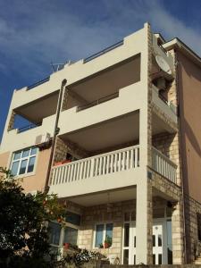 un gran edificio blanco con balcón en Apartments Beleni, en Herceg-Novi