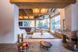 a living room with a table with a bowl of fruit at Chalet Hinterstein in Scheffau am Wilden Kaiser