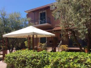 a house with an umbrella in front of it at Kefalonia apartments - Marias studios in Spartia in Spartia