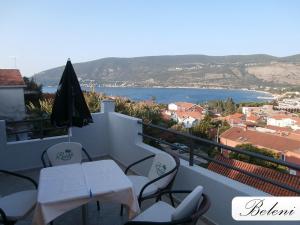 d'un balcon avec des tables et des chaises et une vue sur l'eau. dans l'établissement Apartments Beleni, à Herceg-Novi