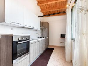 uma cozinha com armários brancos e um forno com placa de fogão em Belvilla by OYO Villa Manca em Santa Giusta
