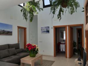 un salon avec un canapé et une table avec des fleurs dans l'établissement Casa Bárbara, à Tías