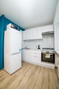 una cucina con armadietti bianchi e frigorifero di TF Apartment двокімнатні апартаменти в центрі міста a Poltava