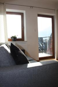 a bedroom with a bed and two windows with a balcony at Krokusowa Polana in Kościelisko