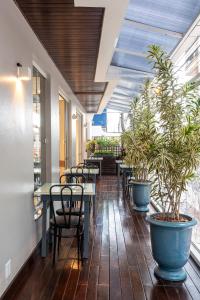 a restaurant with tables and chairs and potted plants at Hotel Negrini in Balneário Camboriú