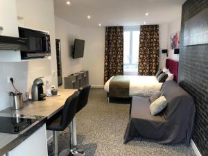 a hotel room with a king sized bed and a kitchen at L' Annexe Beverl'inn in Flers