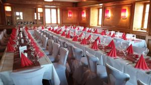 a large room with tables and chairs with red napkins at Gasthaus zum Ochsen in Herrischried