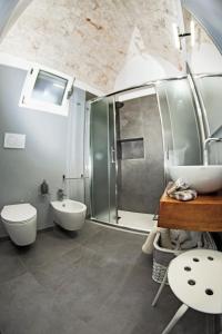 een badkamer met een douche, een toilet en een wastafel bij Elaion Home in Ostuni