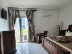 a bedroom with a bed and a sliding glass door at Hotel Impérial in Libreville