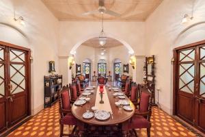 SaffronStays Parsi Manor, Matheran في ماتيرن: غرفة طعام كبيرة مع طاولة وكراسي طويلة