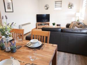 sala de estar con sofá negro y mesa en Inverness City Centre Apartment with Elevator and Google Chromecast, en Inverness