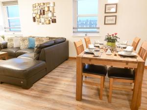 a living room with a couch and a dining room table at Inverness City Centre Apartment with Elevator and Google Chromecast in Inverness