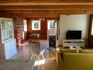 a living room with a couch and a tv at Roubenka Ella in Desná