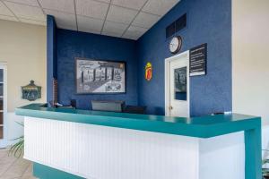 une chambre bleue avec un comptoir et une horloge dans l'établissement Super 8 by Wyndham Cleveland, à North Ridgeville