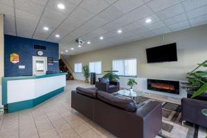 vestíbulo con sofás, chimenea y TV en Super 8 by Wyndham Cleveland, en North Ridgeville