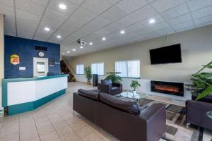 a lobby with couches and a fireplace and a tv at Super 8 by Wyndham Cleveland in North Ridgeville