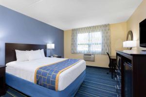 a hotel room with a large bed and a television at Days Inn by Wyndham Augusta in Augusta +18 photos