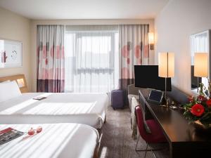 a hotel room with two beds and a desk at Novotel Reading Centre in Reading